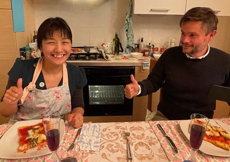 Fabio and Naoko in front of pizza